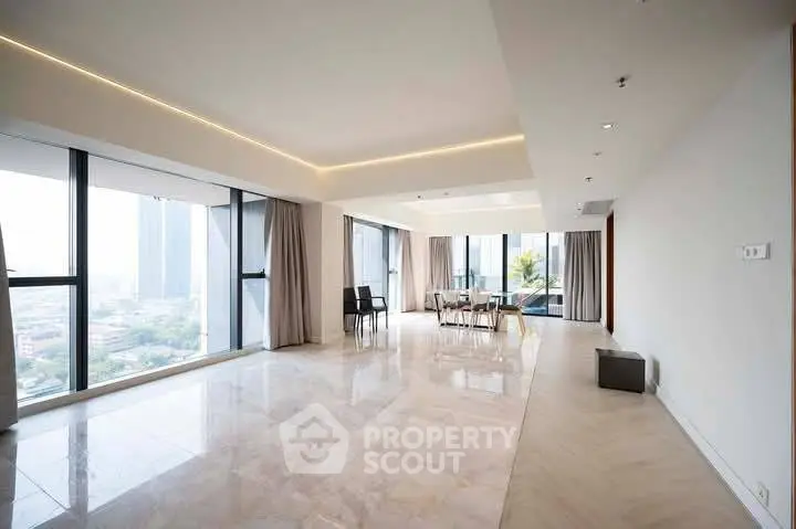 Spacious modern living room with panoramic city views and elegant marble flooring.