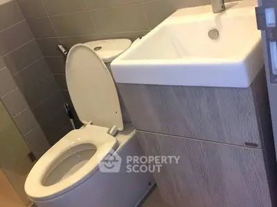 Modern bathroom with sleek sink and toilet in compact design.