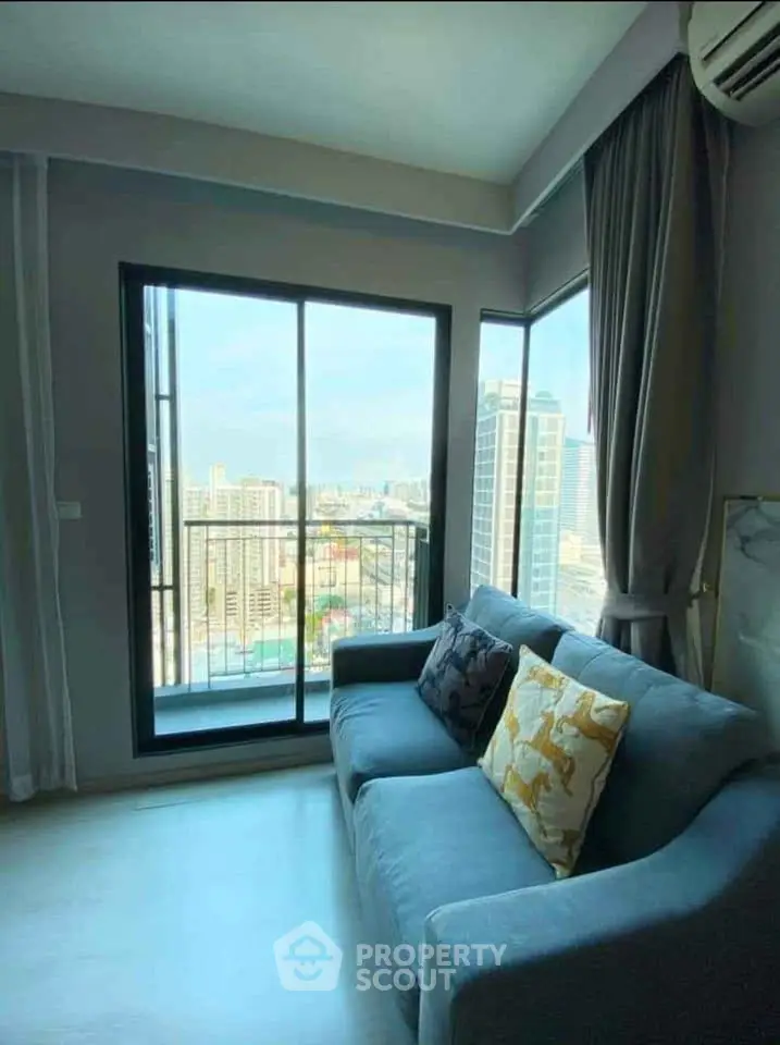 Modern living room with stunning city view from large windows and cozy sofa.