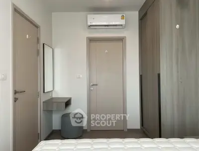 Modern bedroom with air conditioning and sleek storage solutions.