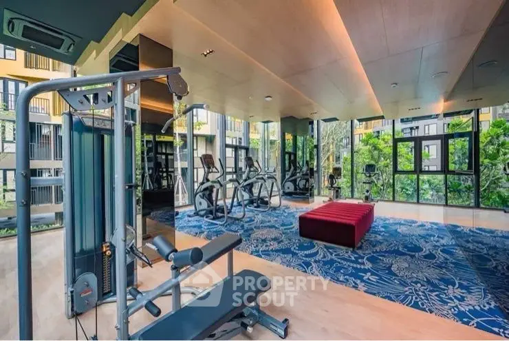 Luxurious gym with modern equipment and scenic garden views in upscale residential building.