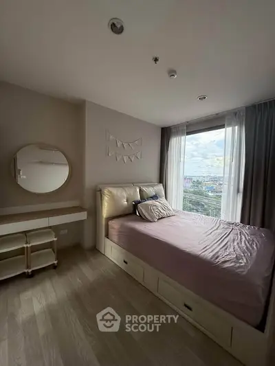 Cozy bedroom with large window offering stunning city views, featuring a stylish bed and modern decor.
