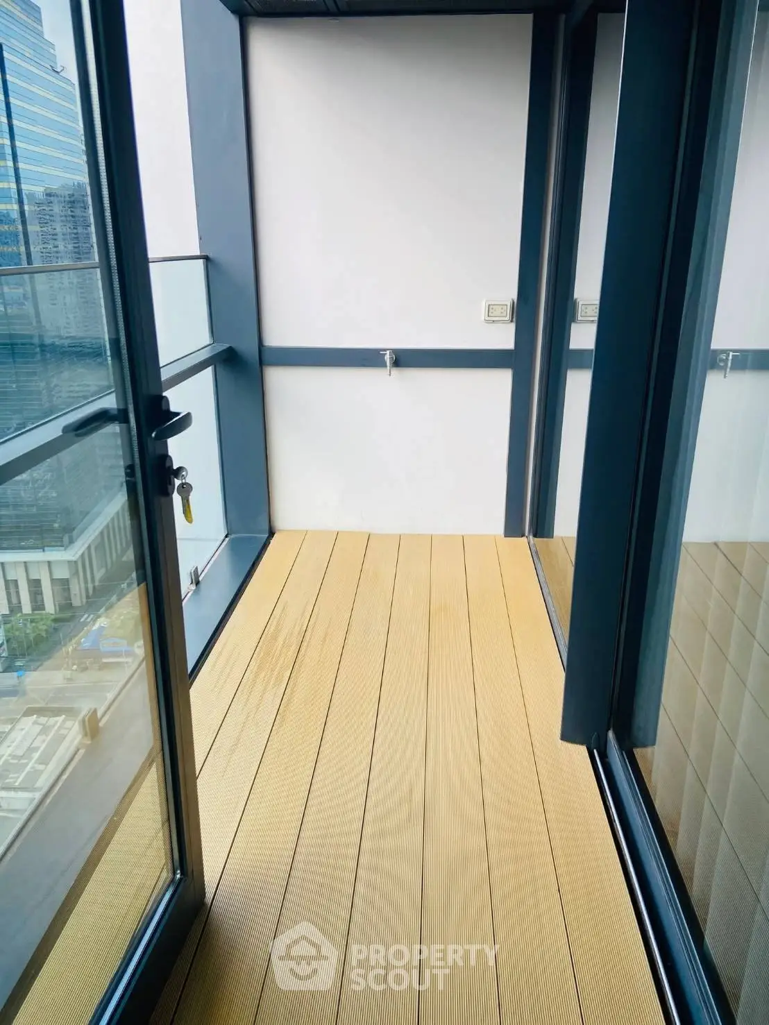 Modern apartment balcony with glass railing and city view