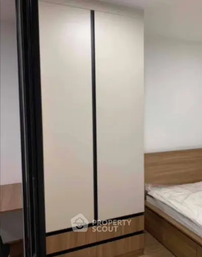 Modern bedroom with sleek wardrobe and cozy bed in a minimalist design.