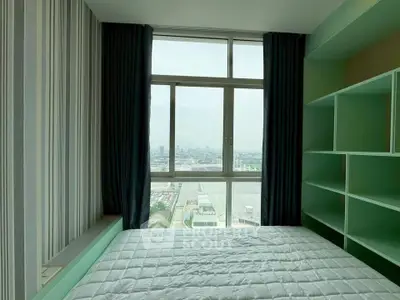 Modern bedroom with large window offering stunning city view and built-in shelving.