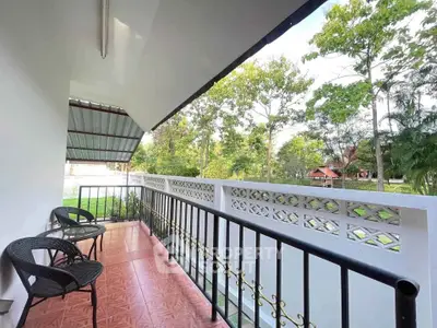 Charming balcony with scenic garden view and cozy seating area, perfect for relaxation.