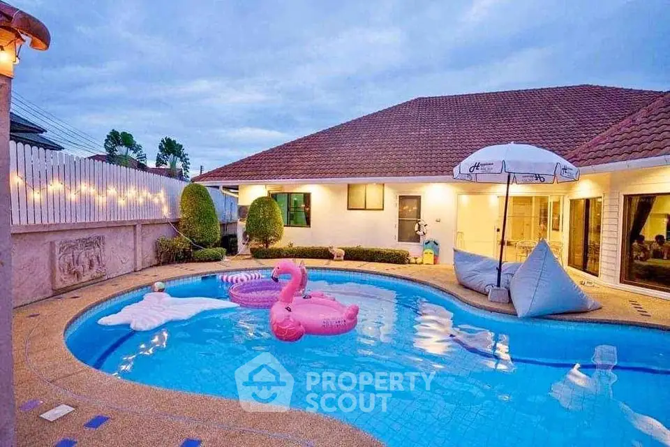 Charming villa with inviting pool and playful inflatables, perfect for relaxation and entertainment.