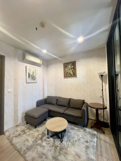 Cozy living room with modern sofa and stylish decor in a well-lit apartment.