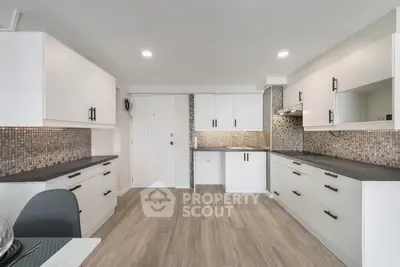 Modern kitchen with sleek cabinetry and stylish backsplash in a spacious open layout.