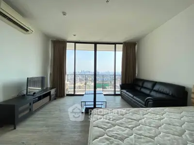Spacious living room with city view, modern furniture, and large windows in a high-rise apartment.