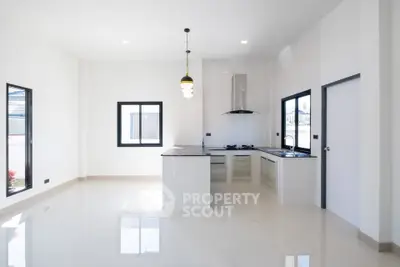 Modern kitchen with sleek design and open layout, featuring large windows and contemporary lighting.
