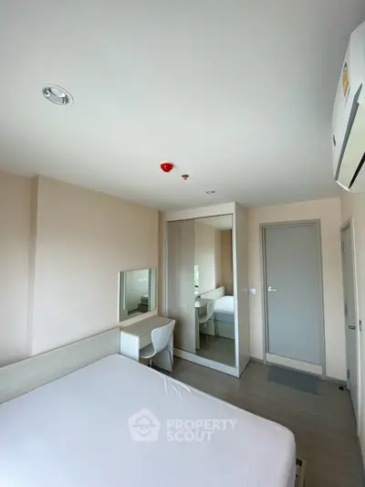 Modern bedroom with minimalist design featuring a large mirror and sleek furniture.
