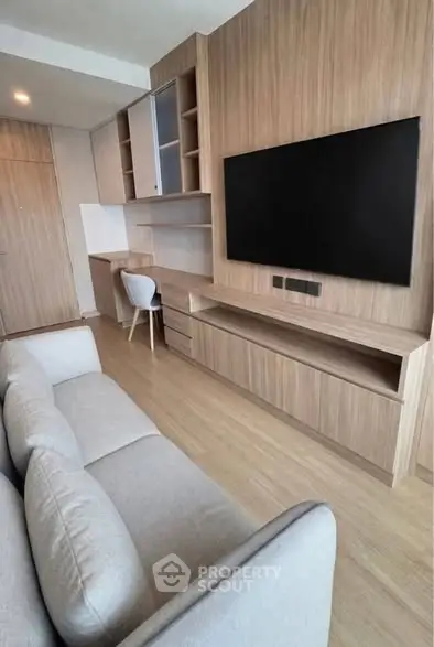 Modern living room with sleek wooden cabinetry and large flat-screen TV, perfect for contemporary living.