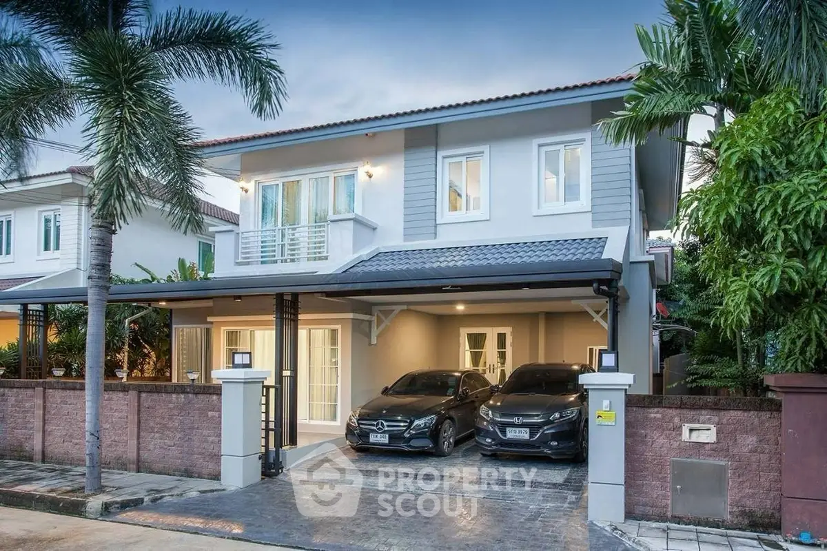 Luxurious modern house with two-car garage and palm trees in a serene neighborhood.
