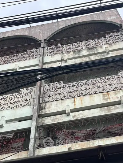 Vintage building exterior with ornate ironwork balconies and weathered facade.