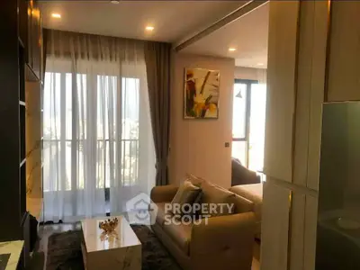 Modern living room with elegant decor and large windows offering natural light.