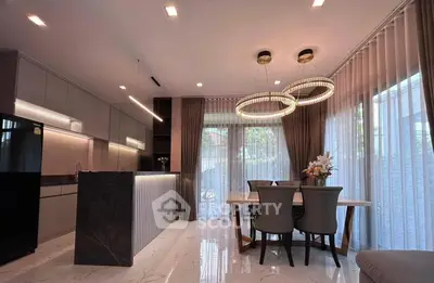 Luxurious modern kitchen with elegant dining area and stylish lighting fixtures.
