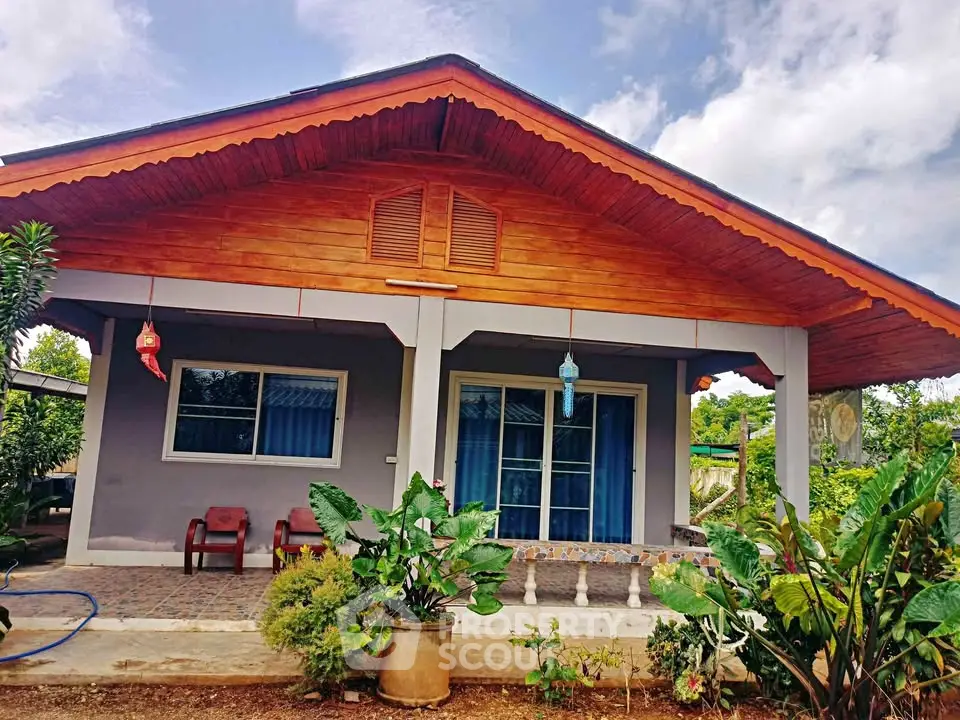 Charming single-story house with a wooden facade and lush garden, perfect for serene living.