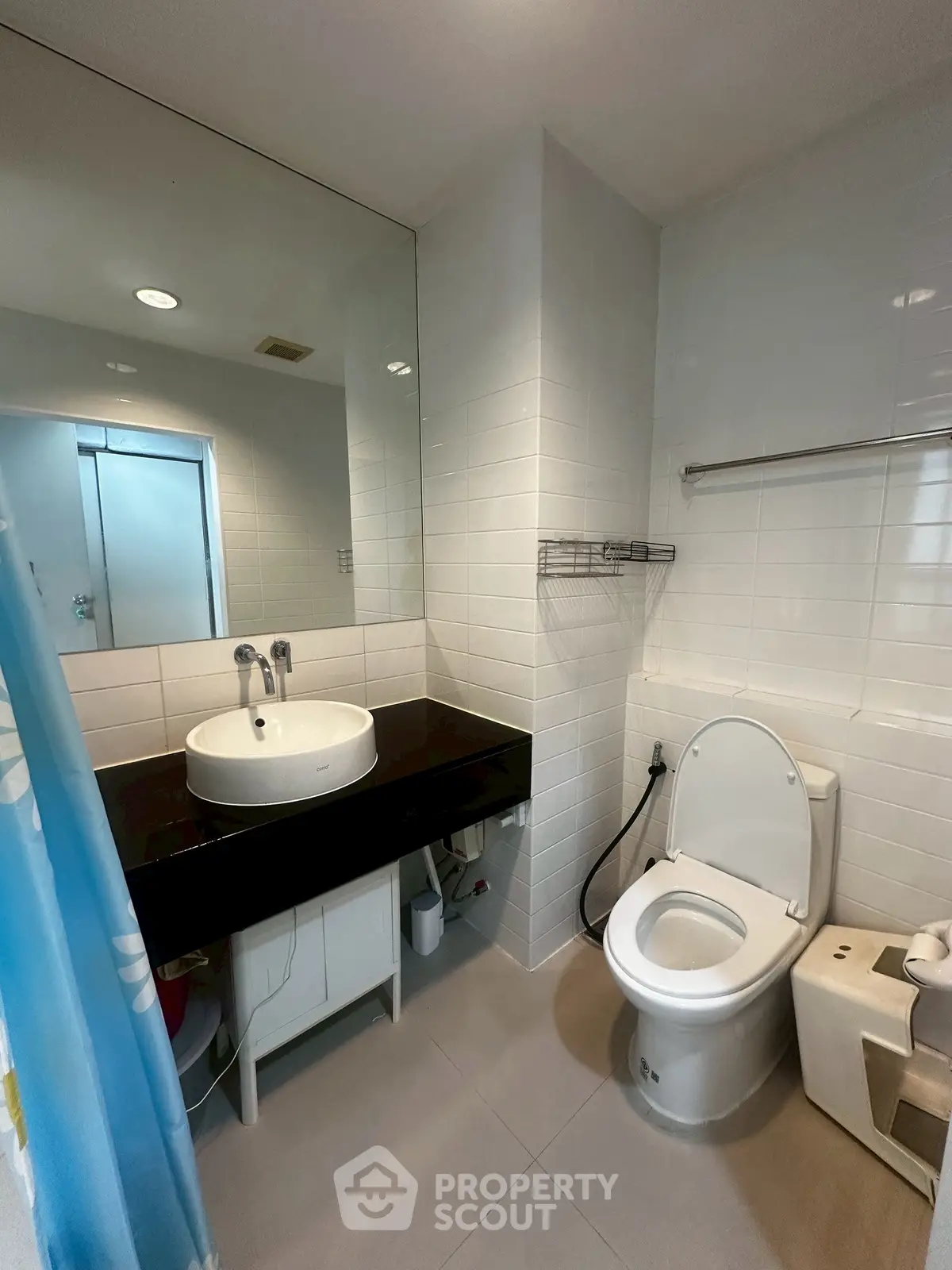 Modern bathroom with sleek fixtures and large mirror in a contemporary apartment.