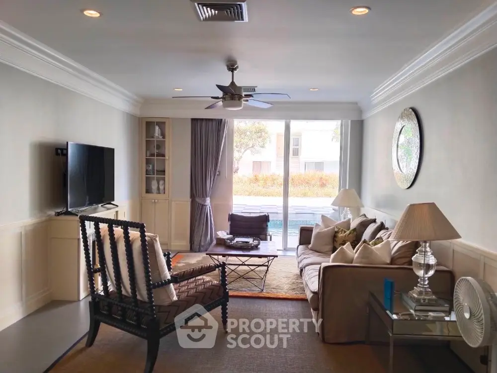 Spacious living room with modern decor and pool view, perfect for relaxation and entertainment.