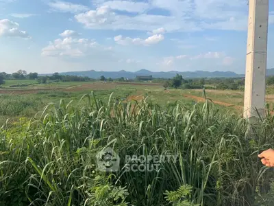 Expansive rural land with scenic mountain views under a clear blue sky.