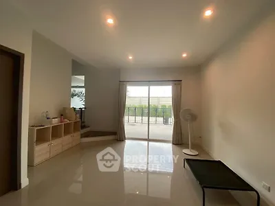 Spacious living room with large windows and balcony access, perfect for natural light and outdoor views.