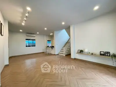 Spacious modern living room with stylish wooden flooring and staircase