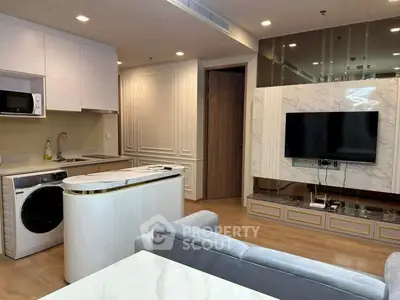 Modern living room with open kitchen, featuring sleek appliances and elegant decor.