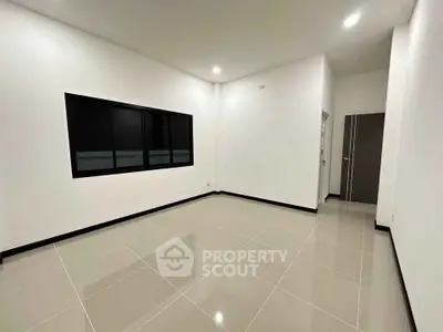 Spacious unfurnished room with sleek tile flooring and modern lighting.