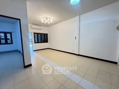 Spacious unfurnished living room with tiled flooring and modern lighting, perfect for customization.