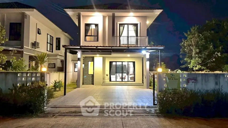 Stunning two-story modern house with illuminated facade and spacious driveway at night.