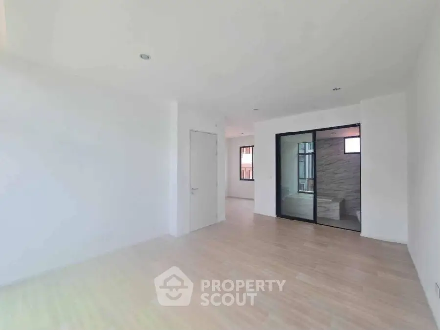 Spacious modern living room with light wood flooring and large windows