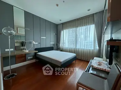 Modern bedroom with large window and sleek furnishings in urban apartment