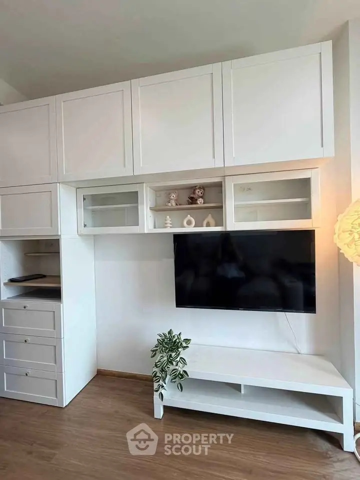Modern living room with sleek white cabinetry and mounted TV, perfect for stylish urban living.