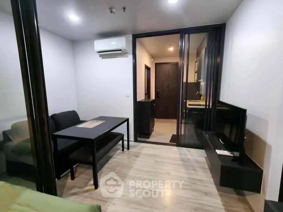 Modern living room with sleek furniture and open kitchen layout in a stylish apartment.