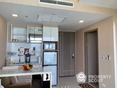 Modern kitchen with sleek appliances and stylish cabinetry in a cozy apartment setting.