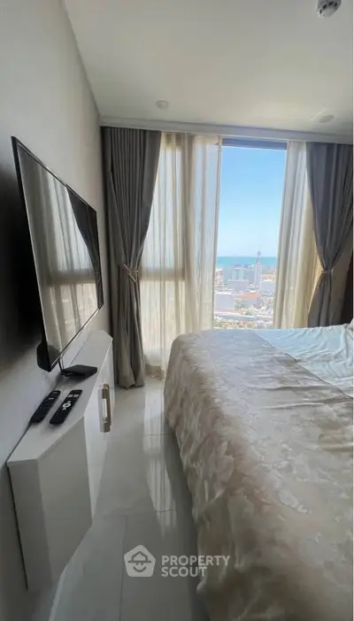 Luxurious bedroom with stunning city view and modern TV setup