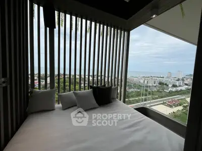 Luxurious balcony with stunning panoramic city and sea view, featuring cozy seating area.