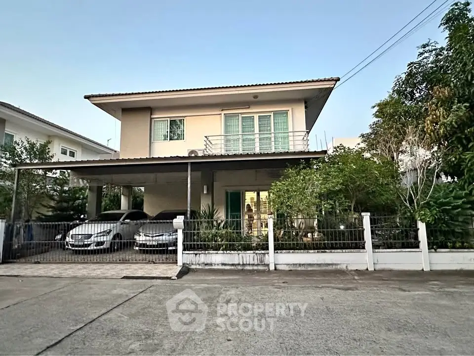 Charming two-story house with spacious driveway and lush greenery, perfect for family living.