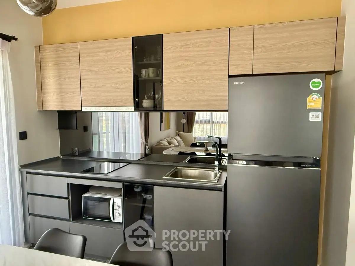 Modern kitchen with sleek black appliances and wooden cabinets