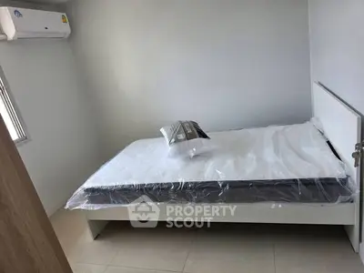 Minimalist bedroom with new bed and air conditioning unit