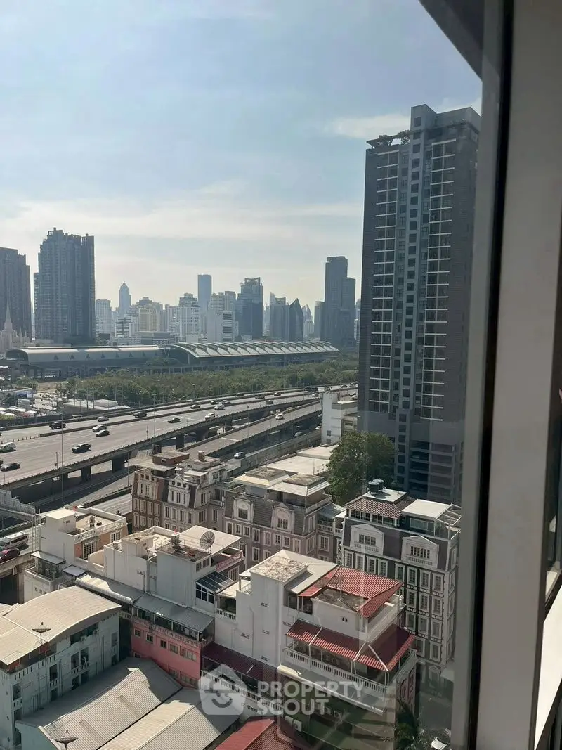 Stunning cityscape view from high-rise apartment window overlooking urban skyline.