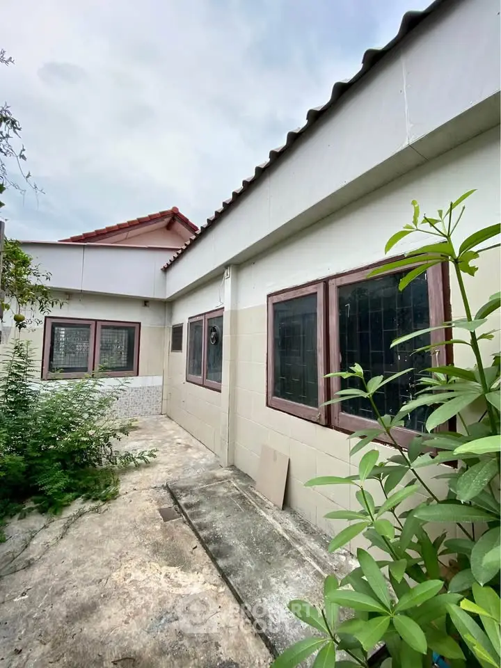 Charming single-story home with lush greenery and spacious outdoor area, perfect for family living.