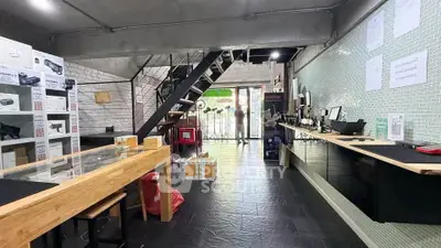 Modern commercial space with industrial design, featuring open layout and stylish staircase, ideal for retail or office use.