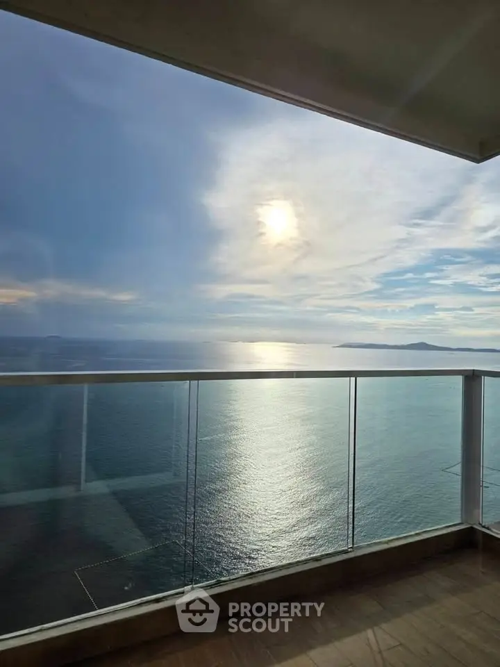 Stunning ocean view from a modern balcony with glass railing, perfect for relaxation and enjoying sunsets.