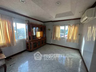 Spacious sunlit room with large windows and air conditioning, perfect for a cozy living space.