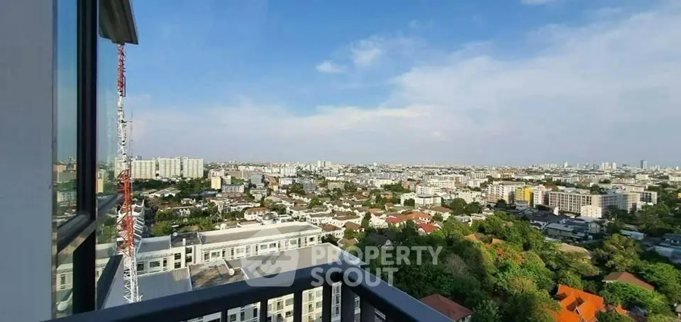 Stunning cityscape view from high-rise balcony with expansive skyline and lush greenery.