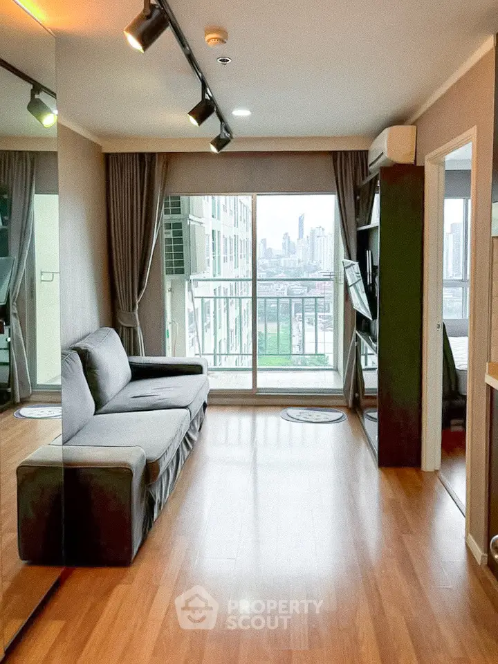 Modern living room with city view, featuring sleek wooden flooring and stylish decor.
