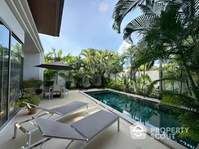 Luxurious private pool area with lush tropical landscaping and modern sun loungers