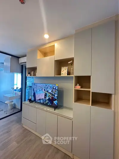 Modern living room with sleek built-in storage and flat-screen TV, showcasing contemporary design and functionality.